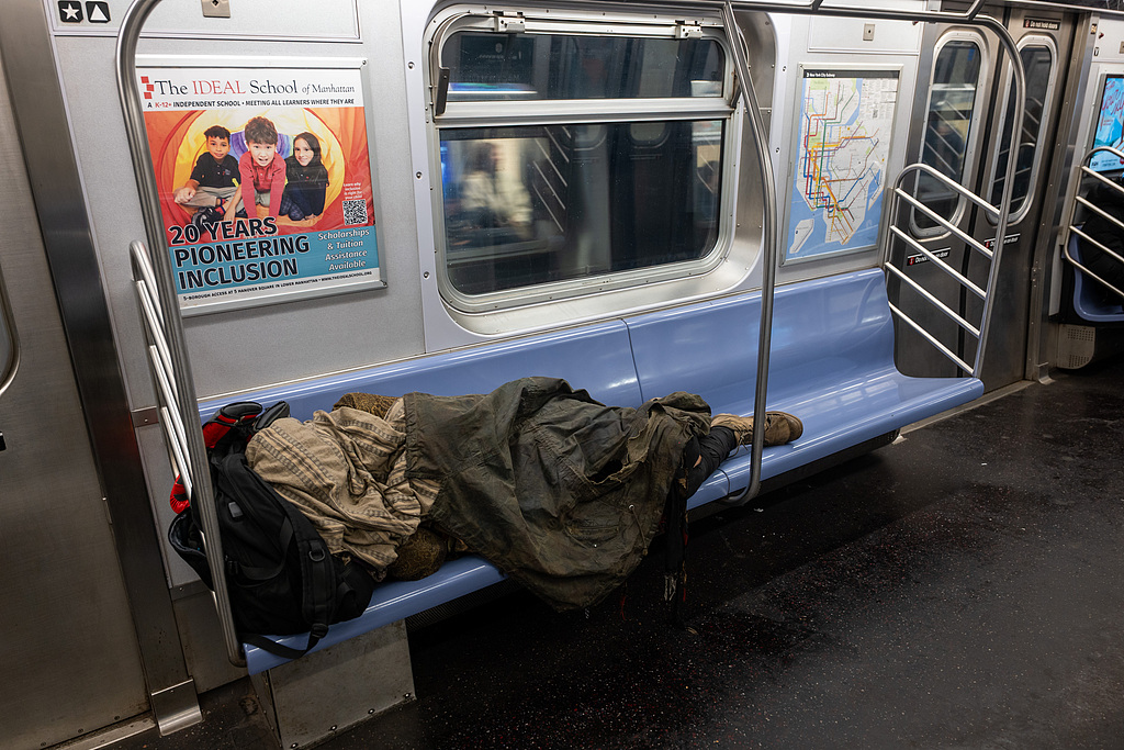Une personne sans abri dort dans un wagon de métro le 29 décembre 2025 à New York. /VCG