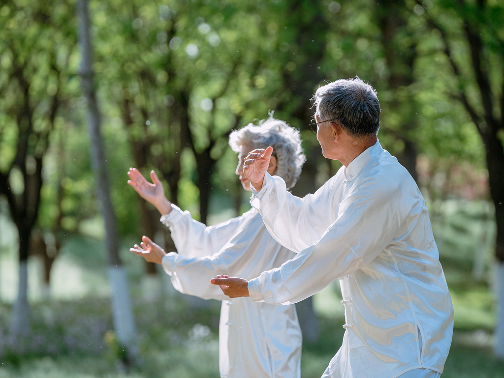 Les gens pratiquent le tai-chi dans le parc. /VCG