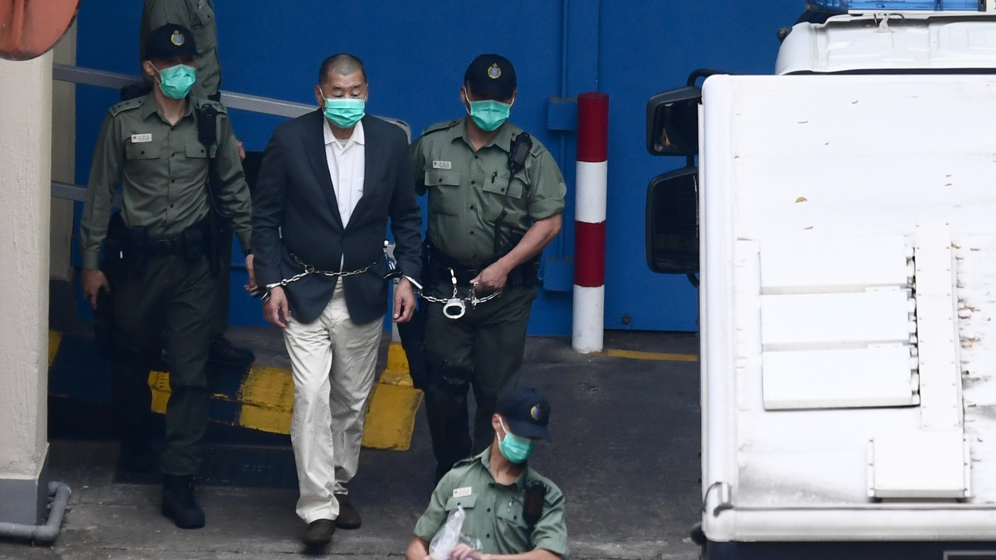 Jimmy Lai est escorté hors du centre de détention par des agents du département des services correctionnels à Hong Kong, dans le sud de la Chine, le 12 décembre 2020. /VCG