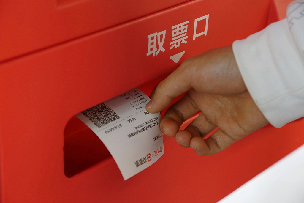 Un cinéphile récupère un billet dans un distributeur automatique de billets en libre-service dans un cinéma de Mengzi, dans la province du Yunnan, le 19 février 2026. /VCG