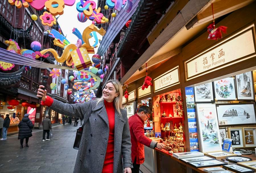 L'étudiante russe Aleksandra Antonenko tourne une courte vidéo sur un stand d'artisanat traditionnel dans le centre commercial Yuyuan Garden à Shanghai, en Chine, le 6 février 2026. /Xinhua