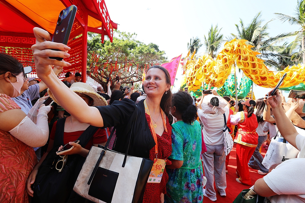 Un touriste étranger prend un selfie à Sanya, province de Hainan, le 20 mars 2026. /VCG
