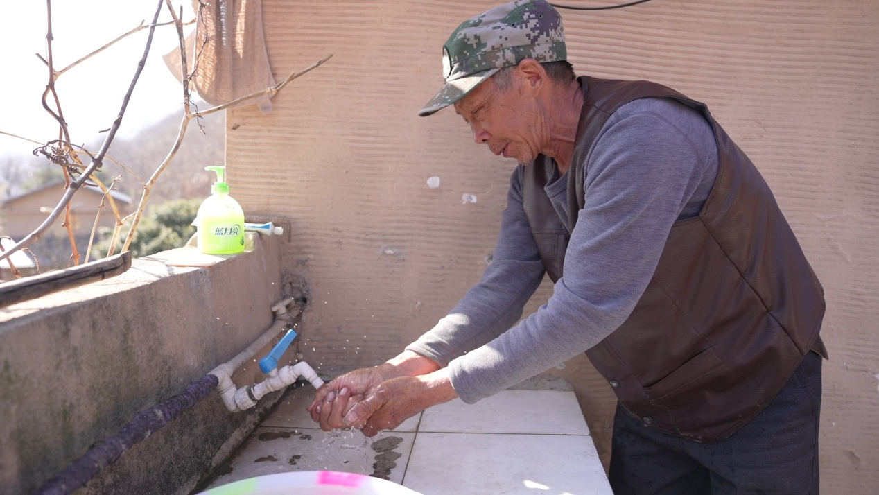 Xiang Yucai, un résident local, se lave les mains à l'eau courante, ce qui, selon lui, a été rendu possible l'année dernière. 