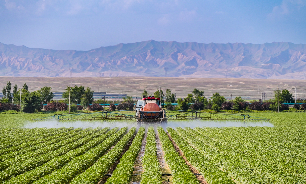 A farmer operates agricultural machinery to spray pesticides on cotton in Changji Hui Autonomous Prefecture in Northwest China