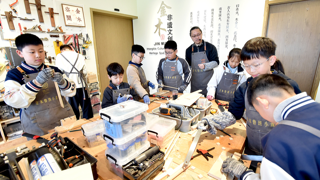 Des étudiants découvrent l'artisanat traditionnel du travail du bois lors d'un atelier pendant leurs vacances de printemps à Yangzhou, dans la province du Jiangsu (est de la Chine), le 2 avril 2026. /VCG