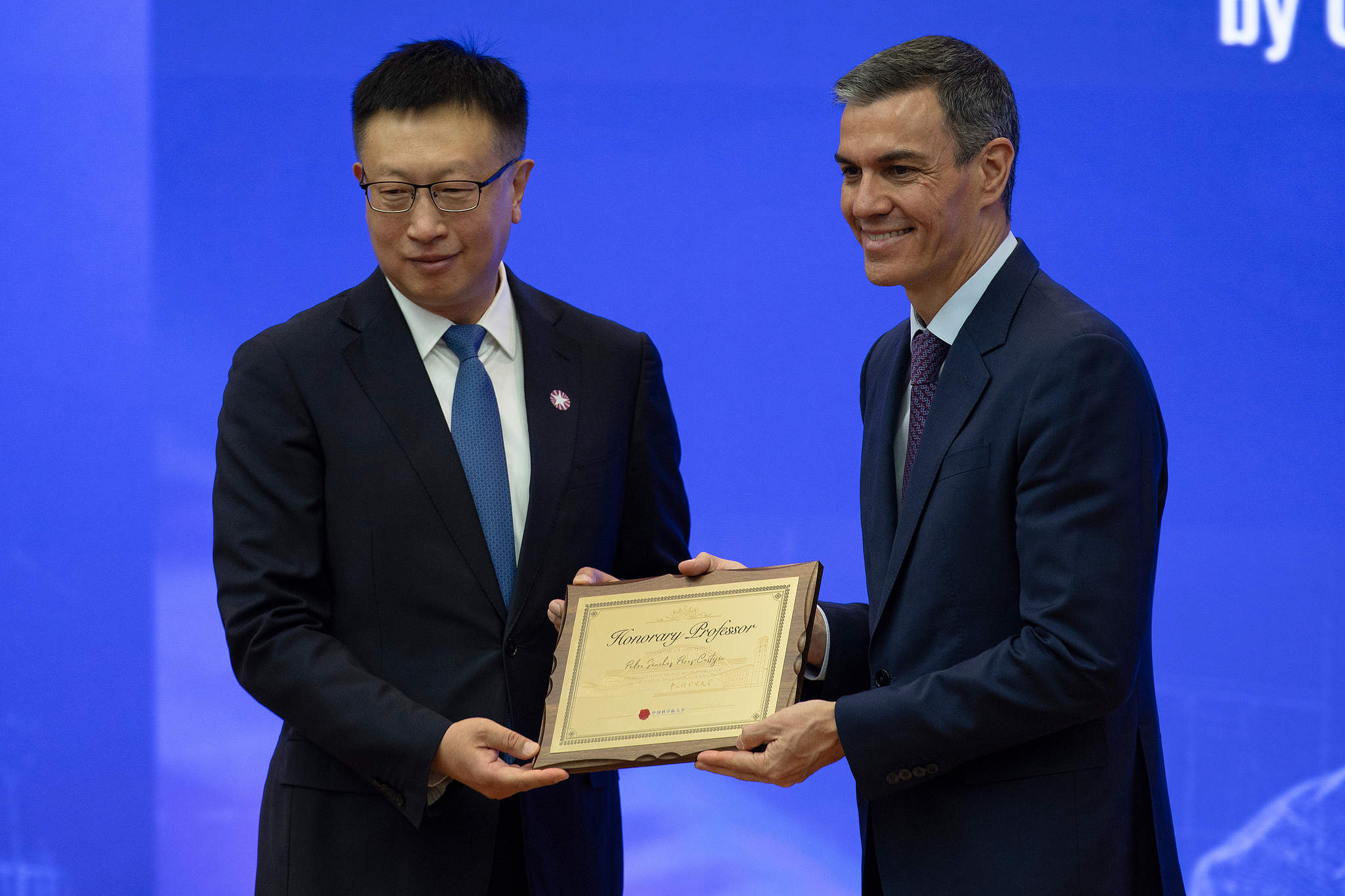 Le Premier ministre espagnol Pedro Sánchez (à droite) pose avec une plaque après avoir été nommé professeur honoraire à l'Université de l'Académie chinoise des sciences à Pékin le 13 avril 2026. /VCG