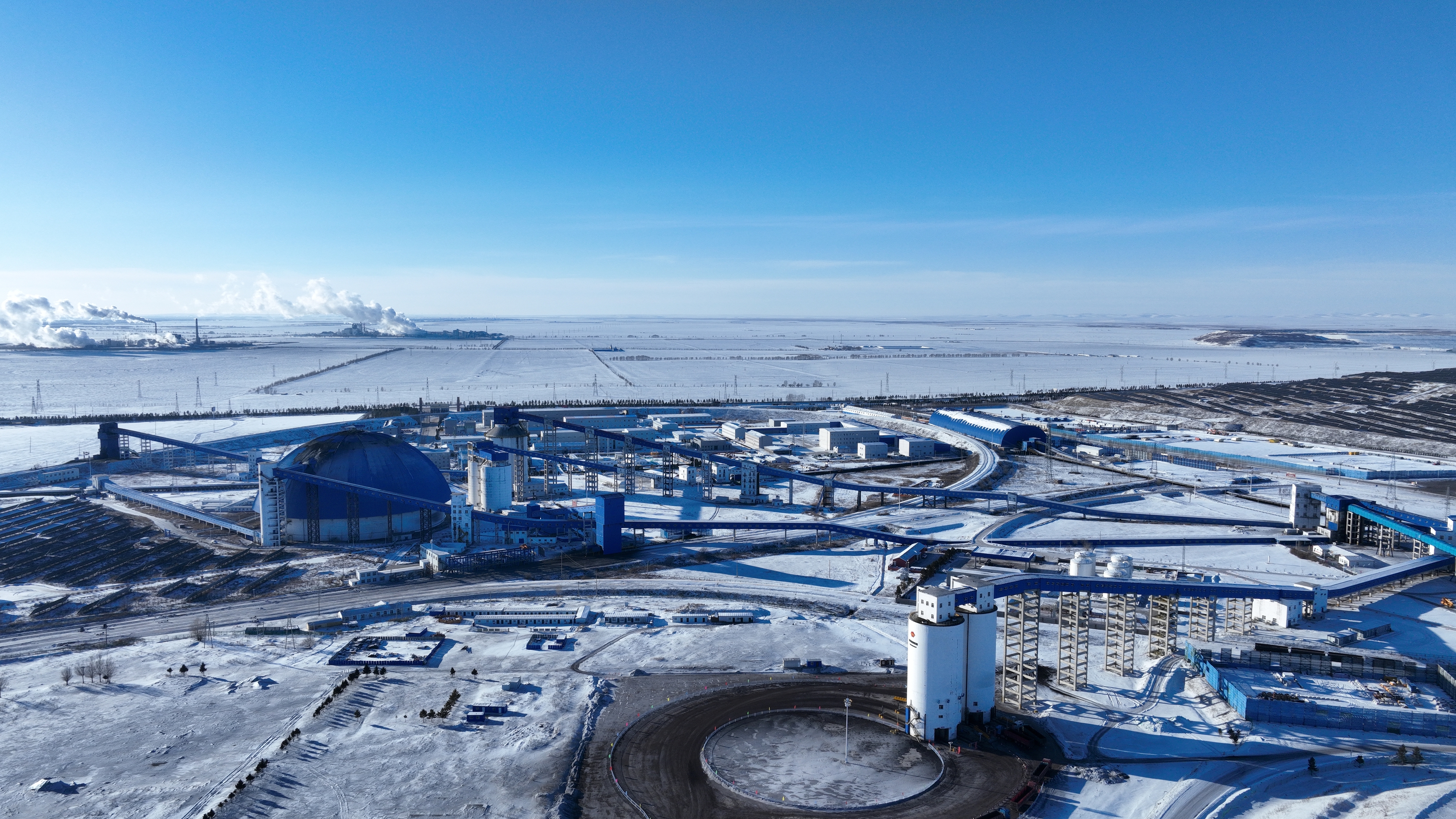 Une base de production de mine de charbon moderne vue sous la neige, montrant un système fermé d'approvisionnement, de stockage et de transport de charbon, en Mongolie intérieure, Chine, le 7 janvier 2026. /VCG