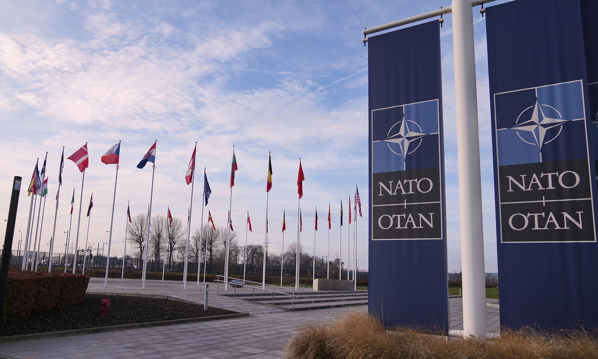 Flags flap in the wind outside NATO headquarters in Brussels, on January 19, 2026. Photo: VCG
