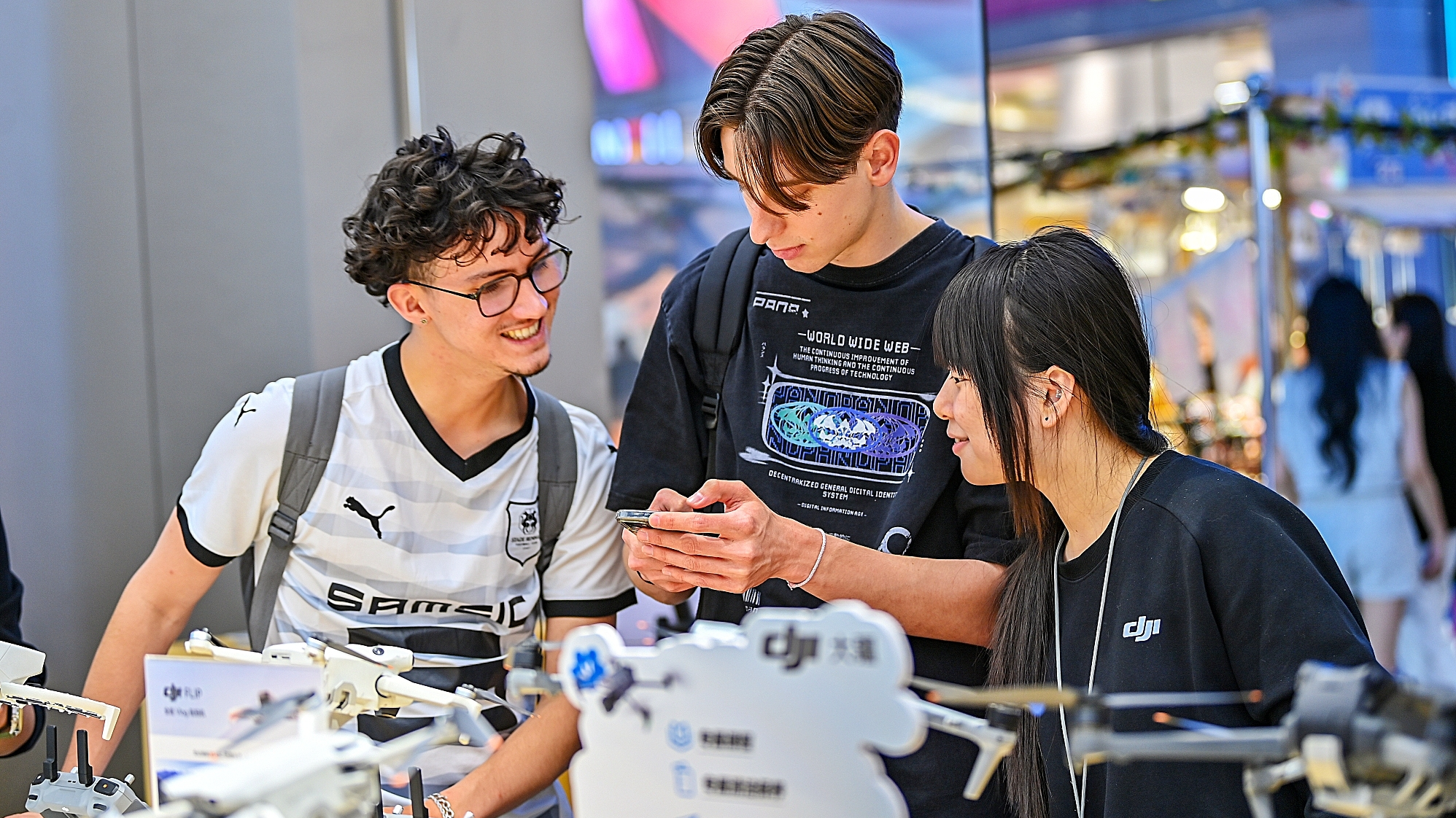 Deux touristes français sélectionnent et achètent des drones dans un magasin de drones de marque chinoise à Wuhan, province du Hubei, centre de la Chine, le 15 avril 2025. /CFP