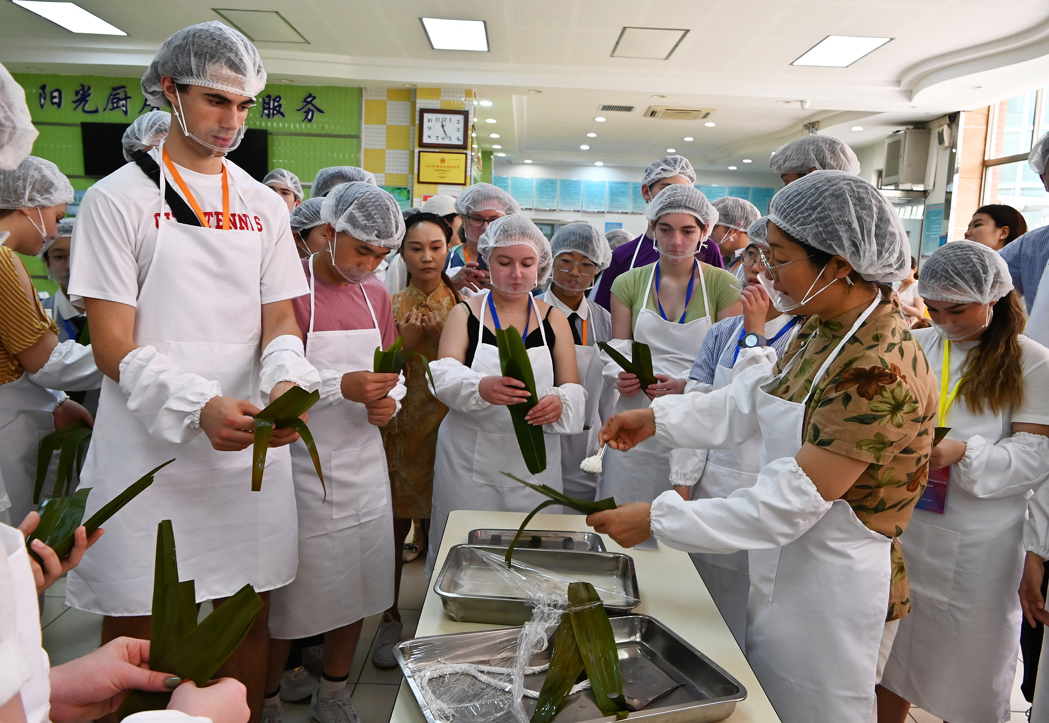 Des étudiants chinois et américains apprennent à fabriquer des zongzi dans une école de Shijiazhuang, en Chine, le 8 juin 2024. /VCG
