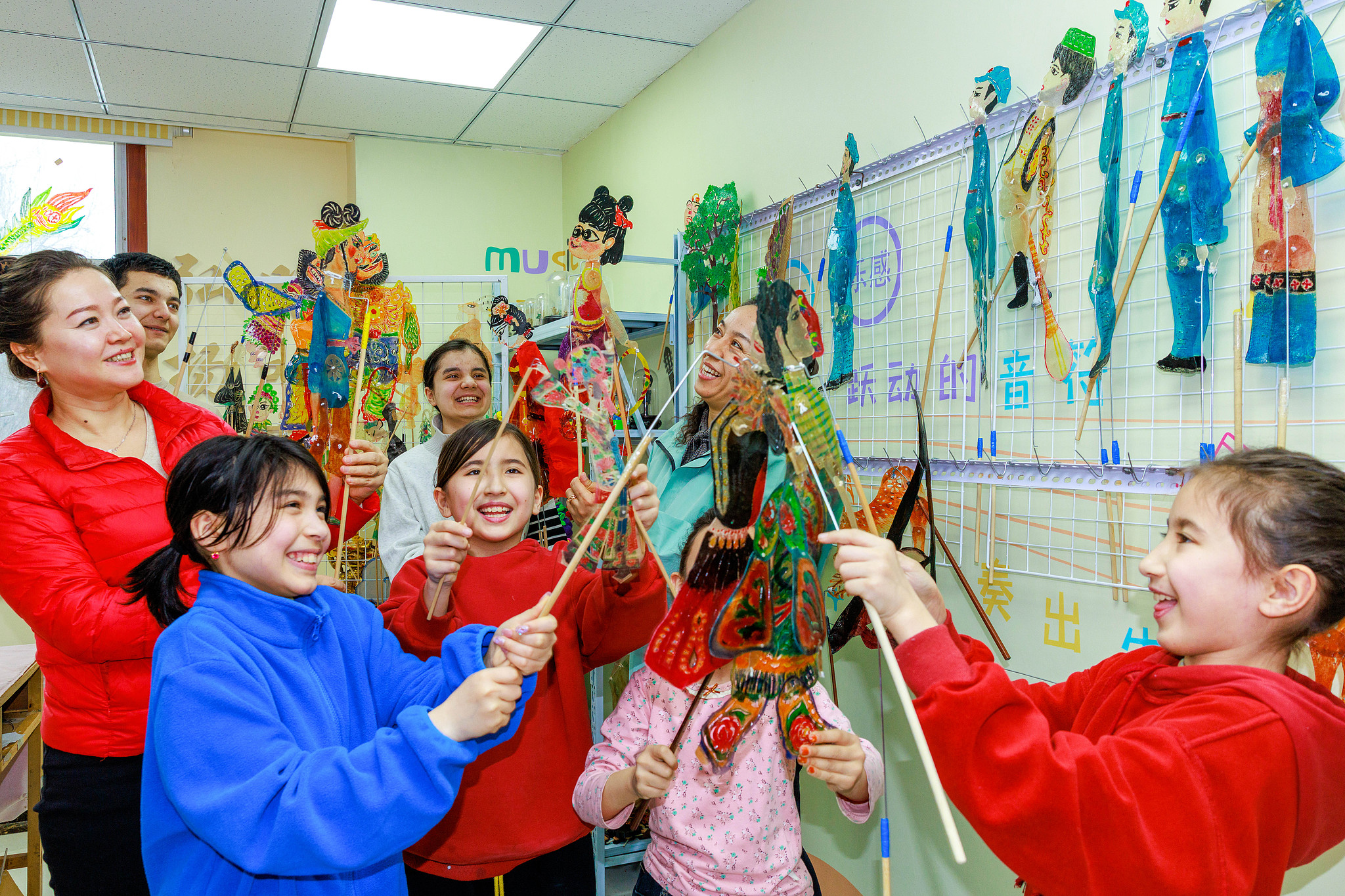 Des enfants assistent à un spectacle de marionnettes d'ombres dans un centre local de services de masse du Parti à Urumqi, dans la région autonome ouïgoure du Xinjiang, dans le nord-ouest de la Chine. /VCG