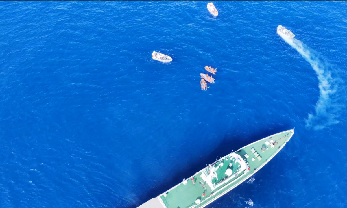 A Philippine rigid inflatable boat from BRP Sierra Madre transfers an injured personnel to another rigid inflatable boat under China Coast Guard vessels’ supervision on October 8, 2026.